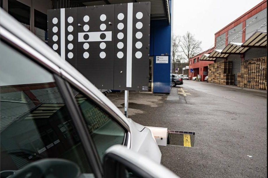 Calibration target for driver assistance systems next to a vehicle at a Steinschlag.ch installation station
