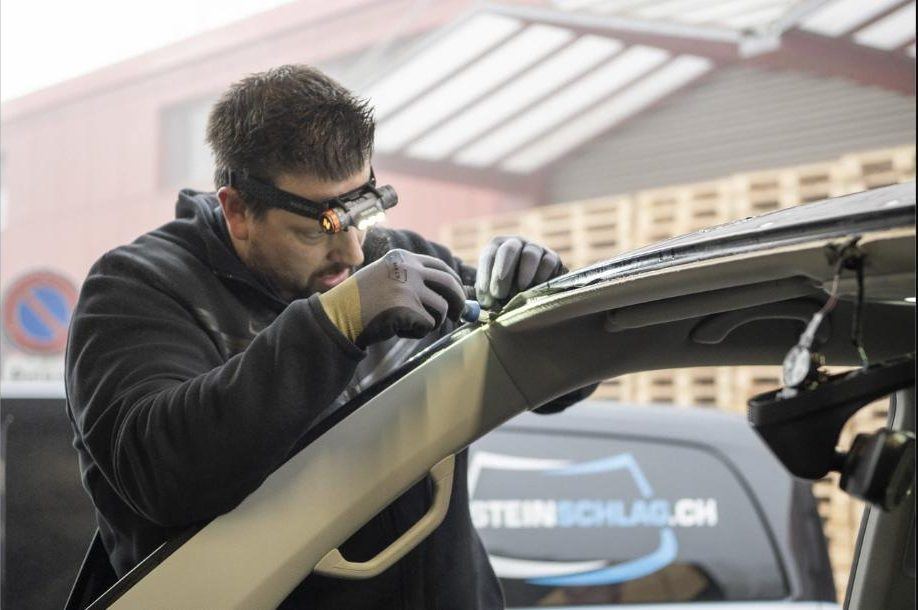 Steinschlag.ch technician with a head torch working on a vehicle window